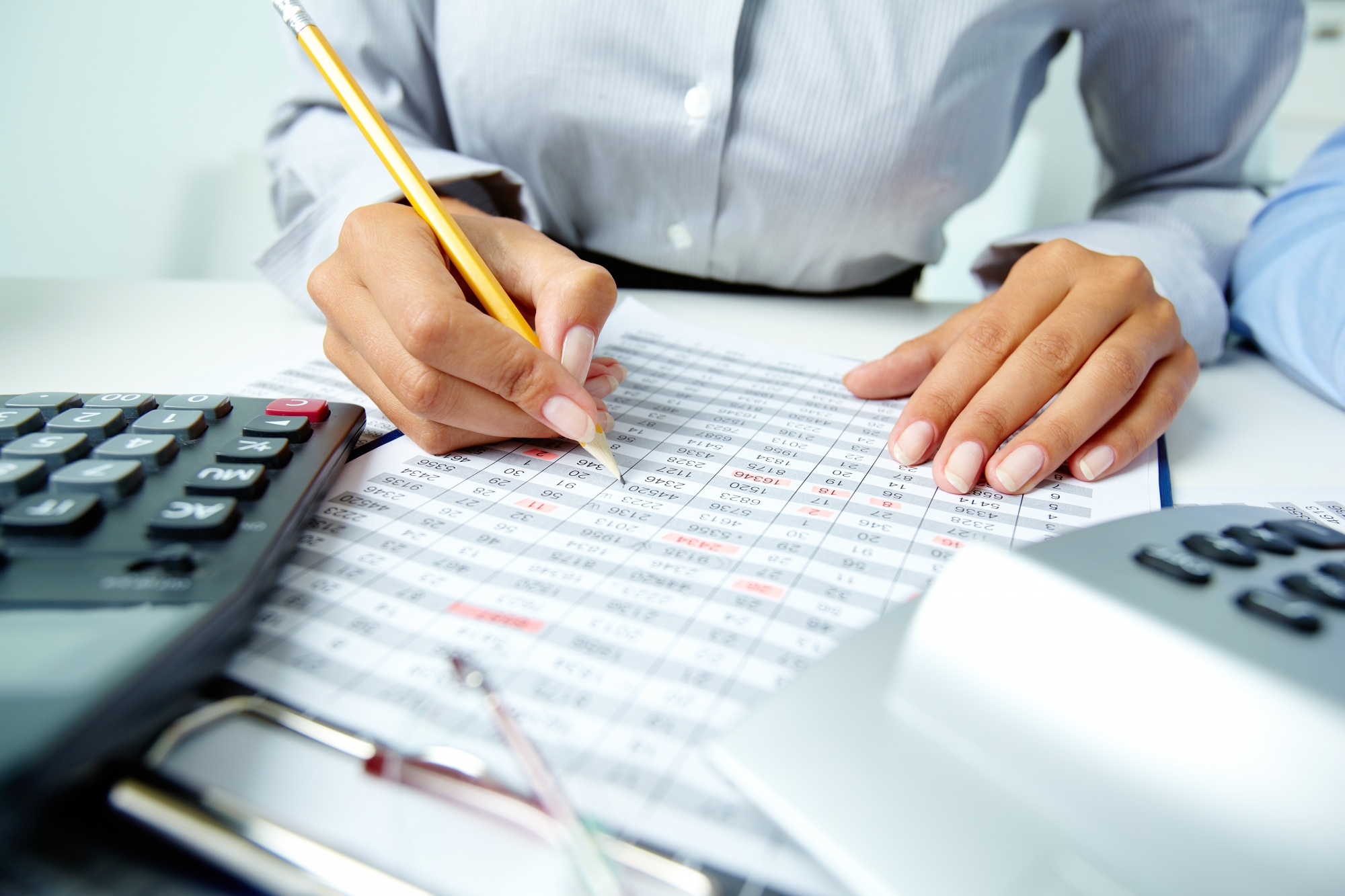 an individual writing on a sheet of numbers